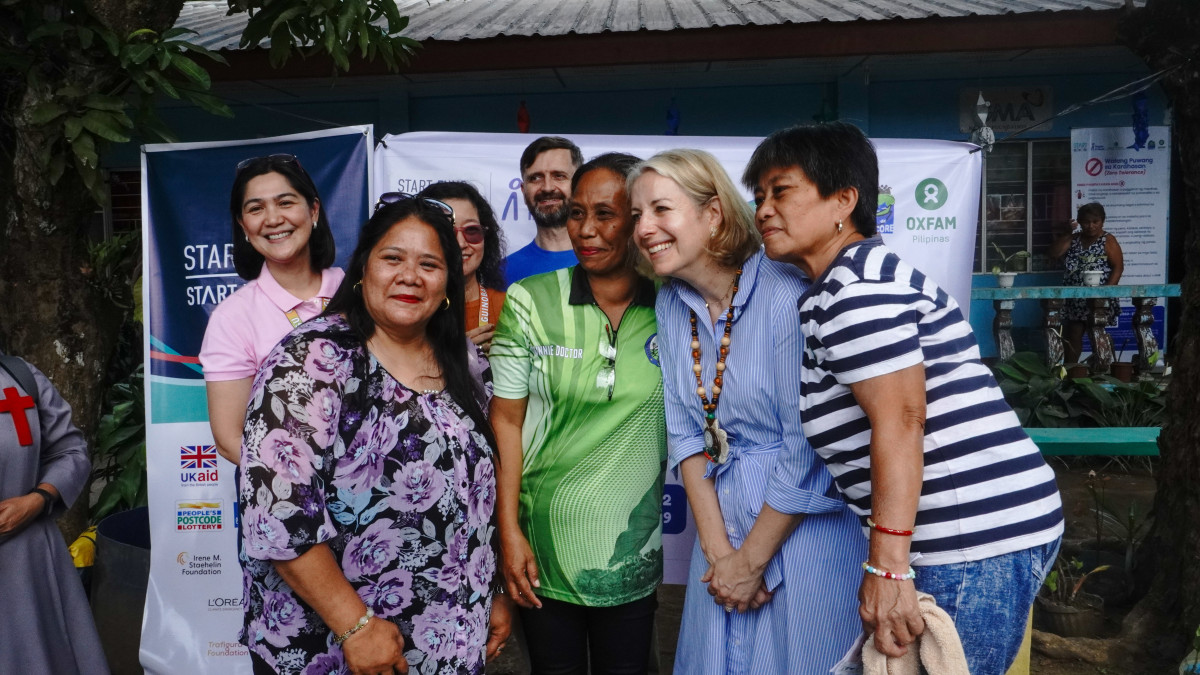 Graduates of the Psychological First Aid training pose for a photo with Ambassador Hulton following a seated discussion during the visit.