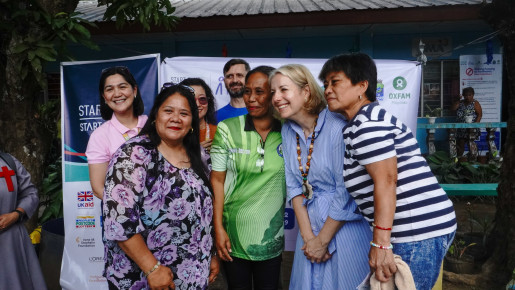 Graduates of the Psychological First Aid training pose for a photo with Ambassador Hulton following a seated discussion during the visit.